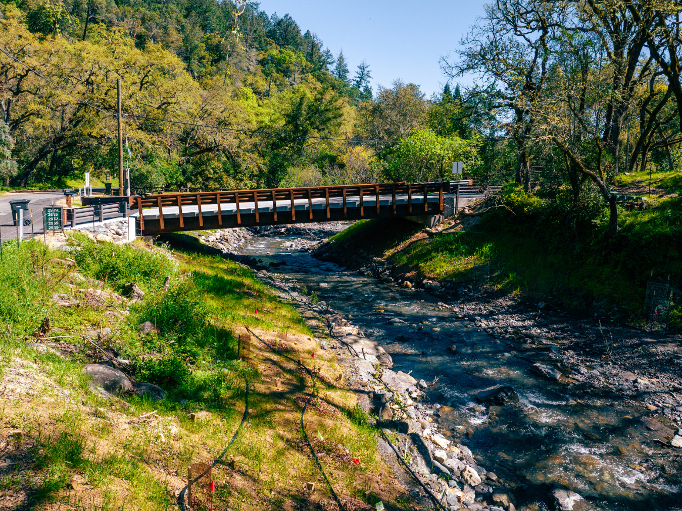 New free-span bridge crossing Sulphur Creek, with rocky streambanks and forested hillsides